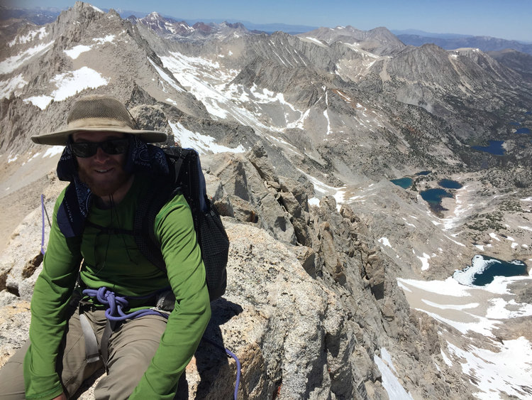 Happy climber sitting on a magnificent peak.