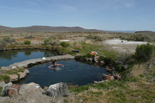 Kathy in Willow Creek Hot Springs, East Escarpment of Steens just visible