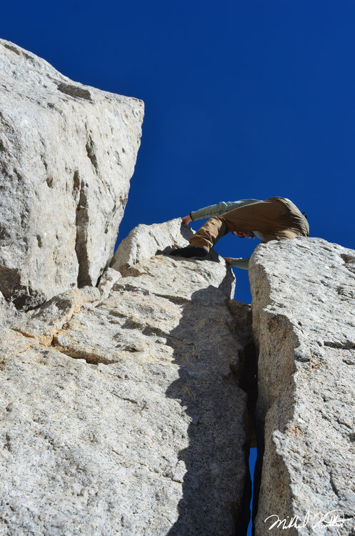 Climbing the final detached block from the summit.
