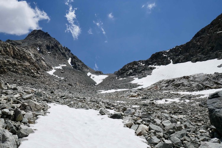 Approach from north from behind rocky prominence. Snow field to the right is the one on the topo.