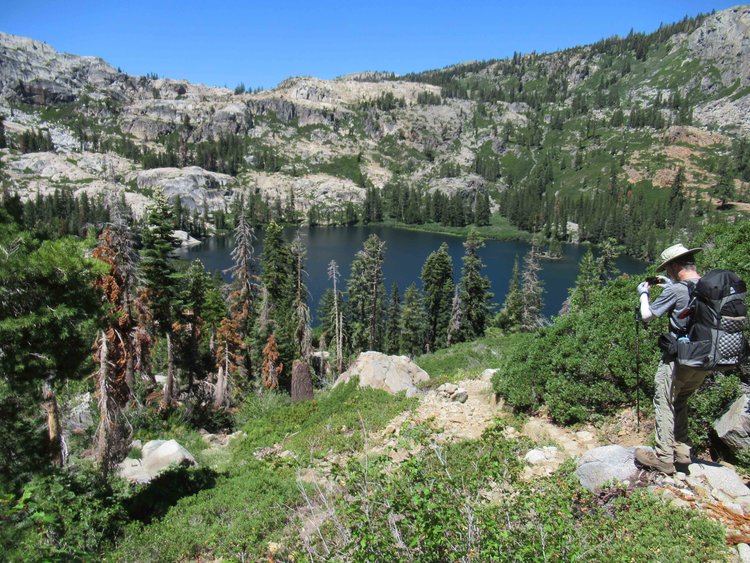 The knee jarring descent offers occasional glimpses of the deep blue lake.